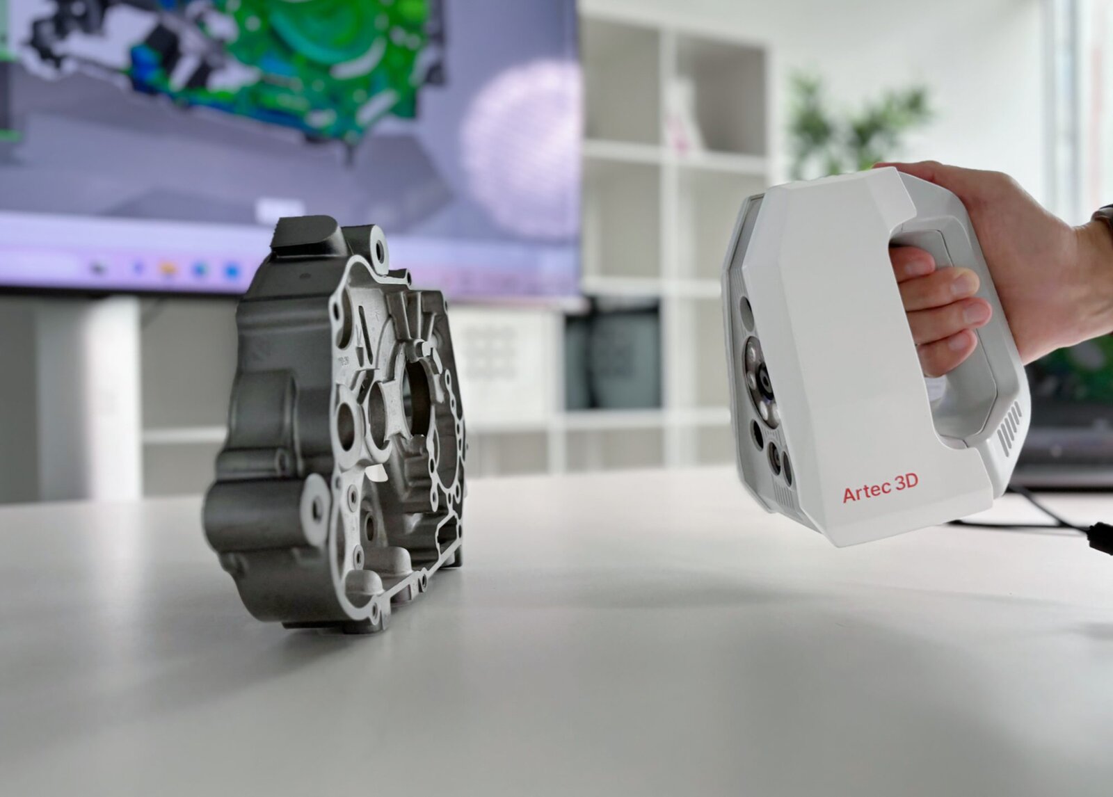 Handheld Artec scanner digitising a metal engine part